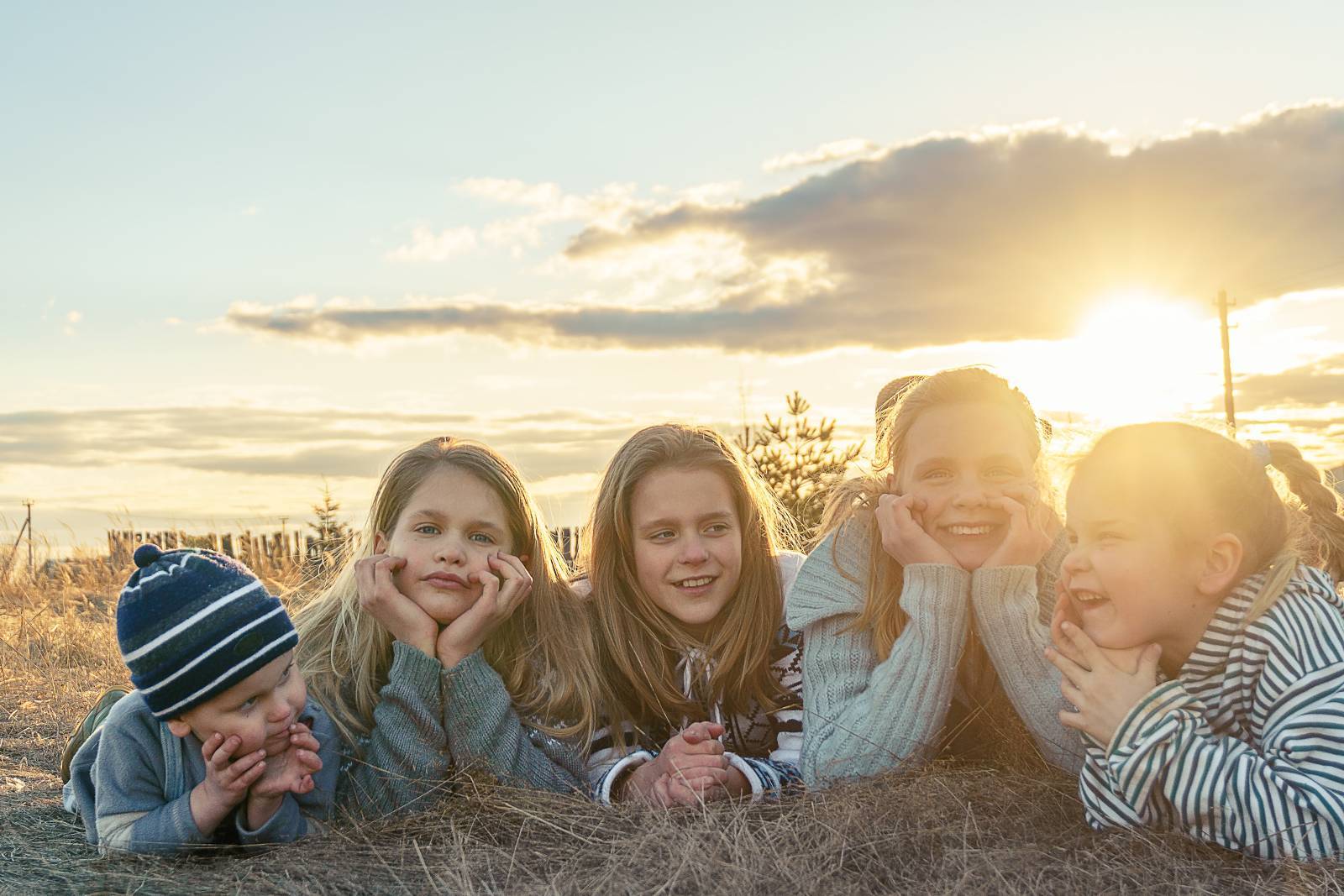 Fünf Kinder liegen im Gras bei Sonnenuntergang - Isbjörn of Sweden